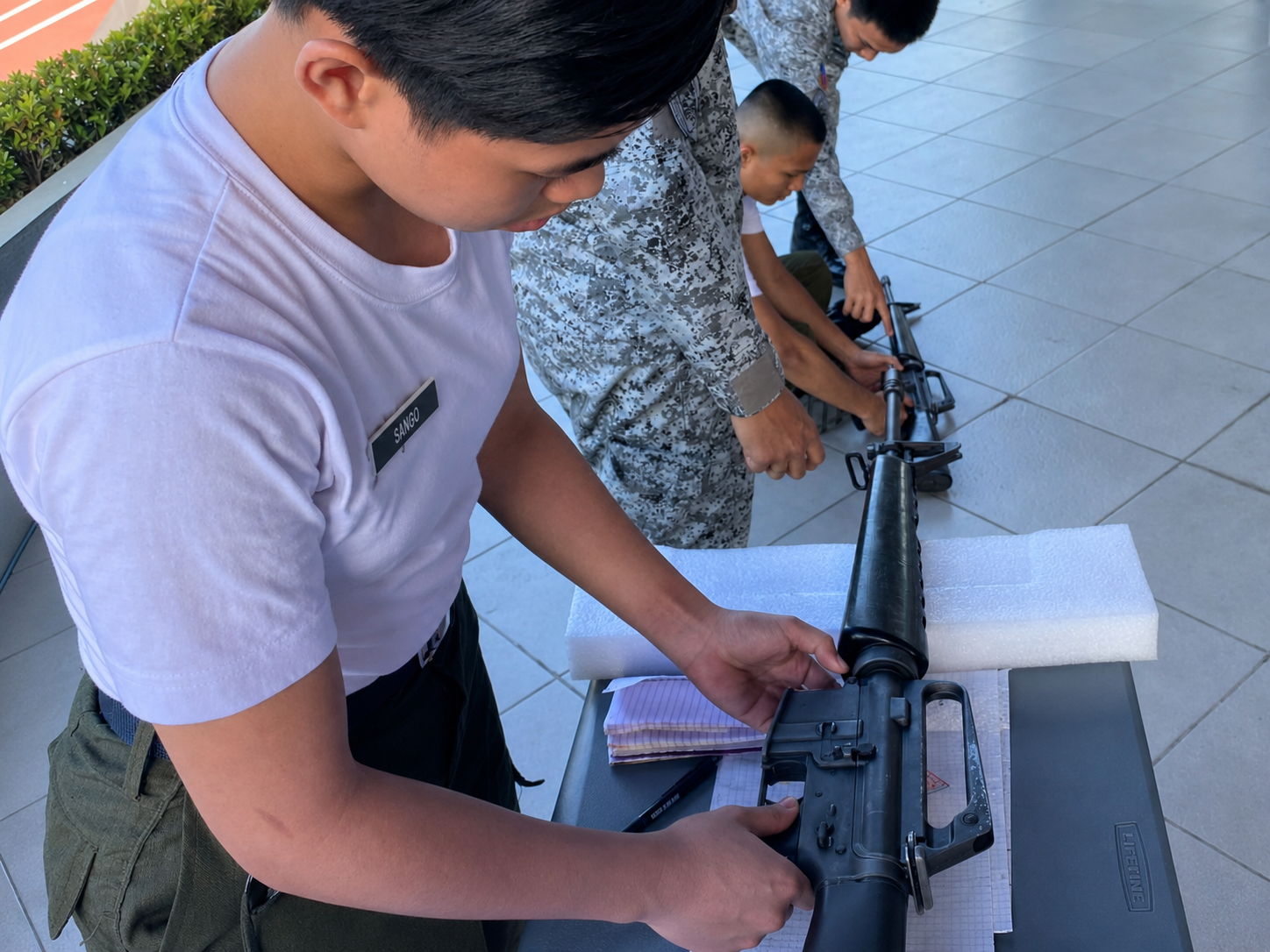 Lacson College criminology student handling training equipment during a supervised safety activity